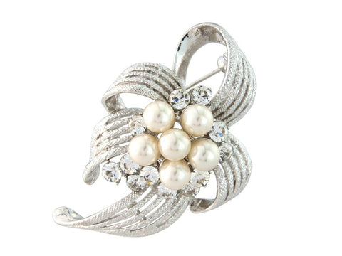 Crystal and pearl brooch in a floral and ribbon design on a rhodium plated finish with Swarovski and cubic zirconia crystals and high quality simulated ivory pearls, brooch measures 5.5cm by 4.5cm